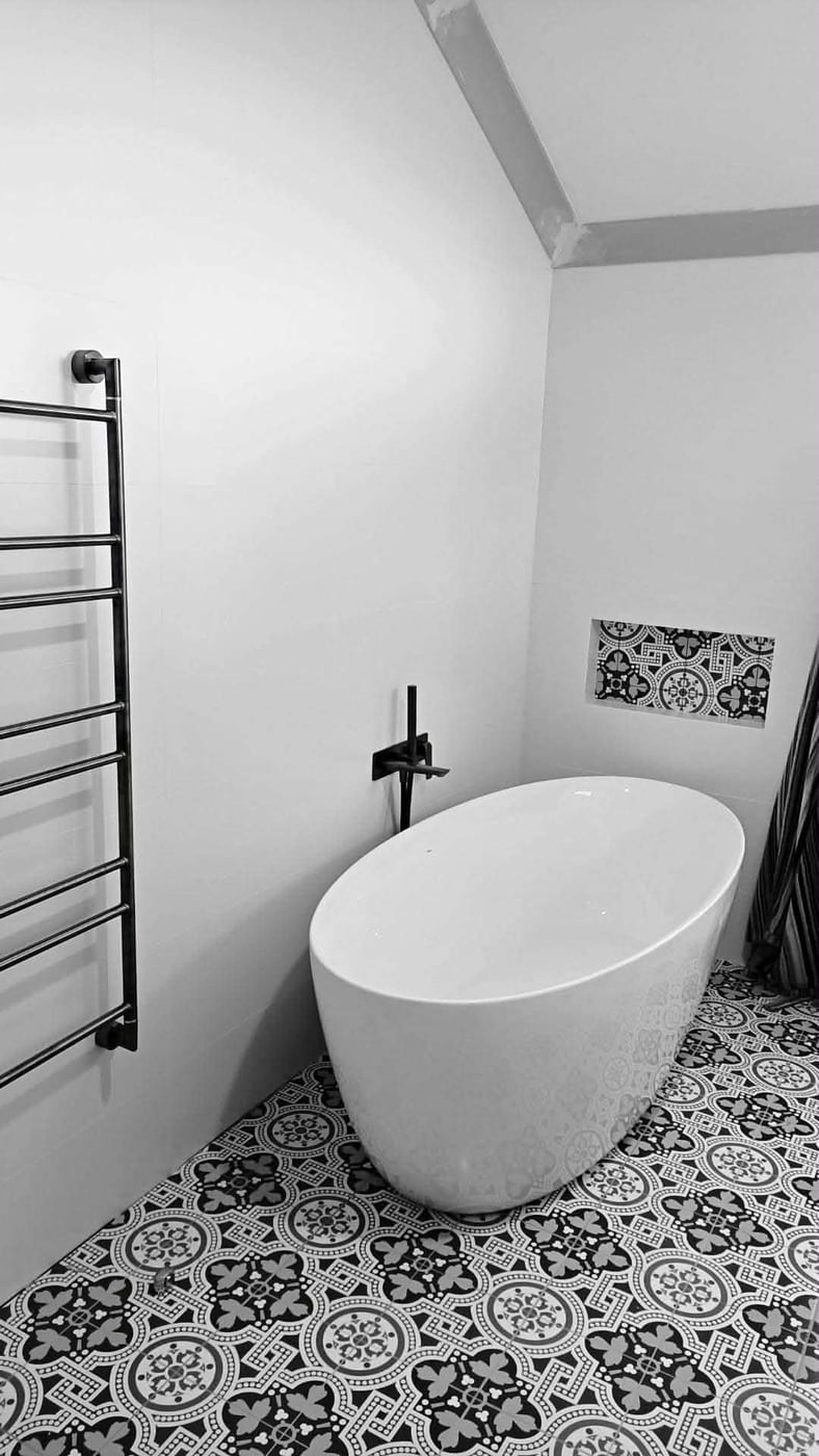 Bathroom with freestanding tub and patterned tile floor